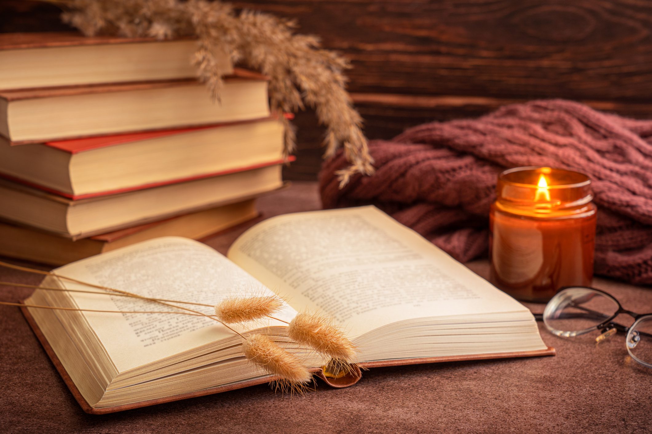 Open book, candle, and cozy autumn decor.