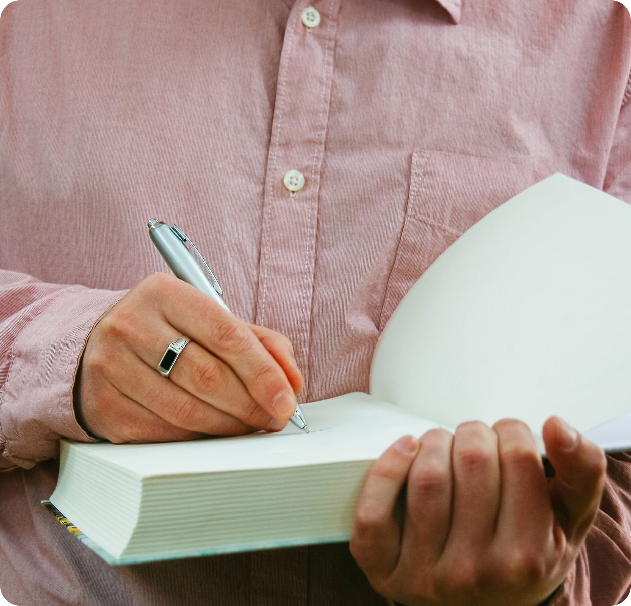 Person writing in an open book.