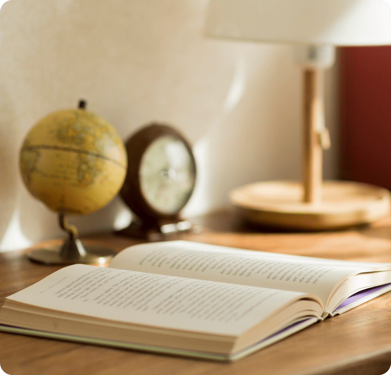 Open book with globe and lamp nearby.