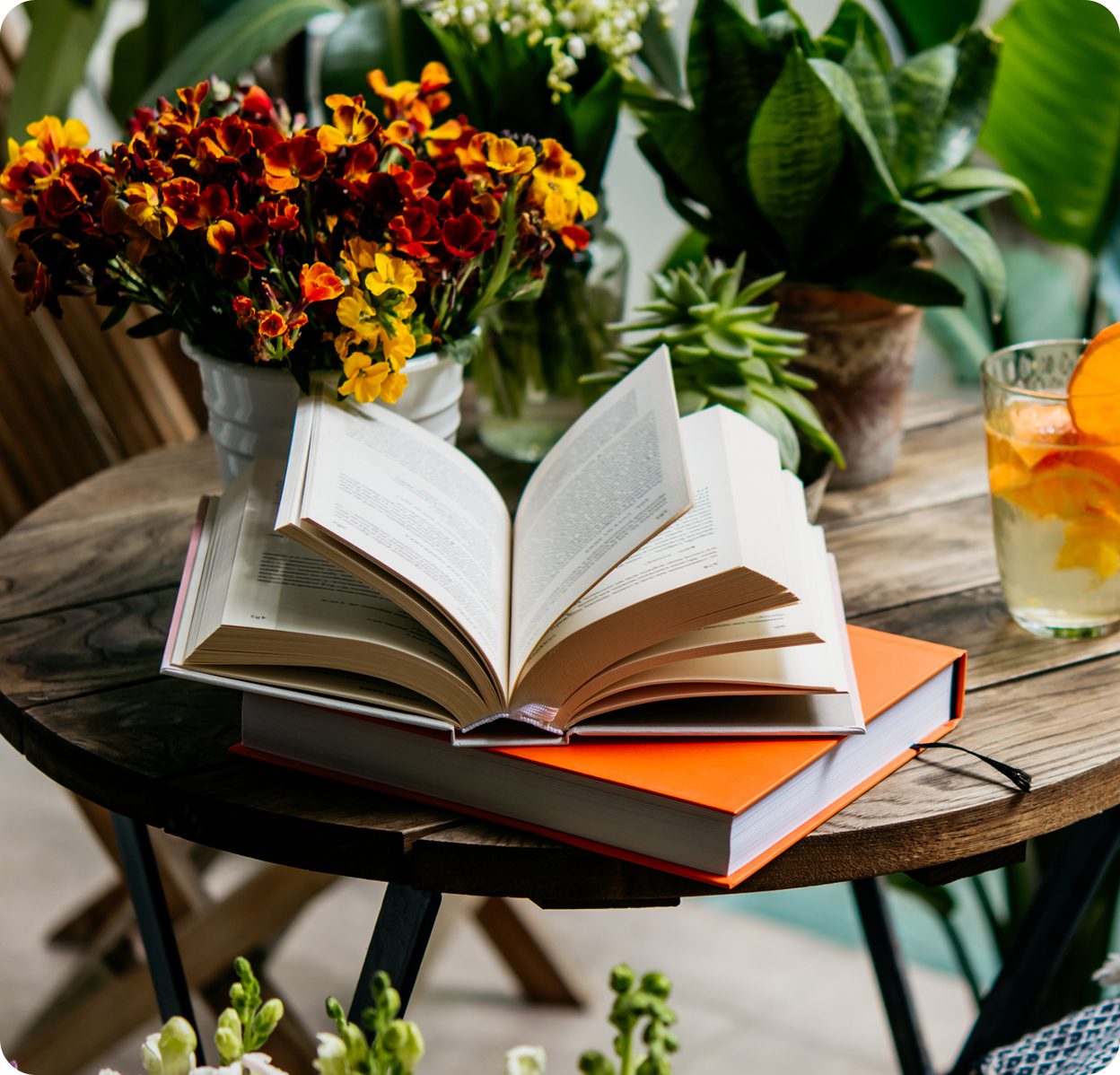Open book on table with flowers.